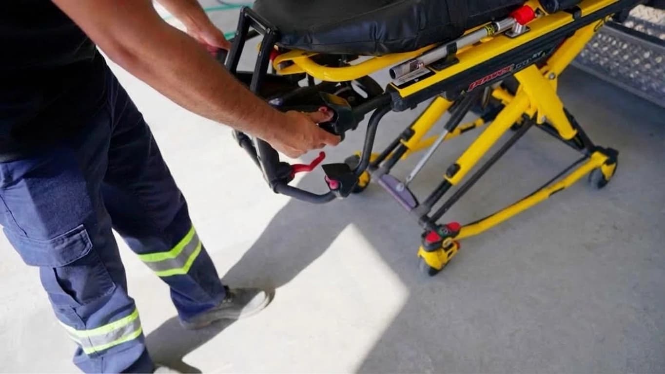 A transport attendant handling the powered stretcher equipment