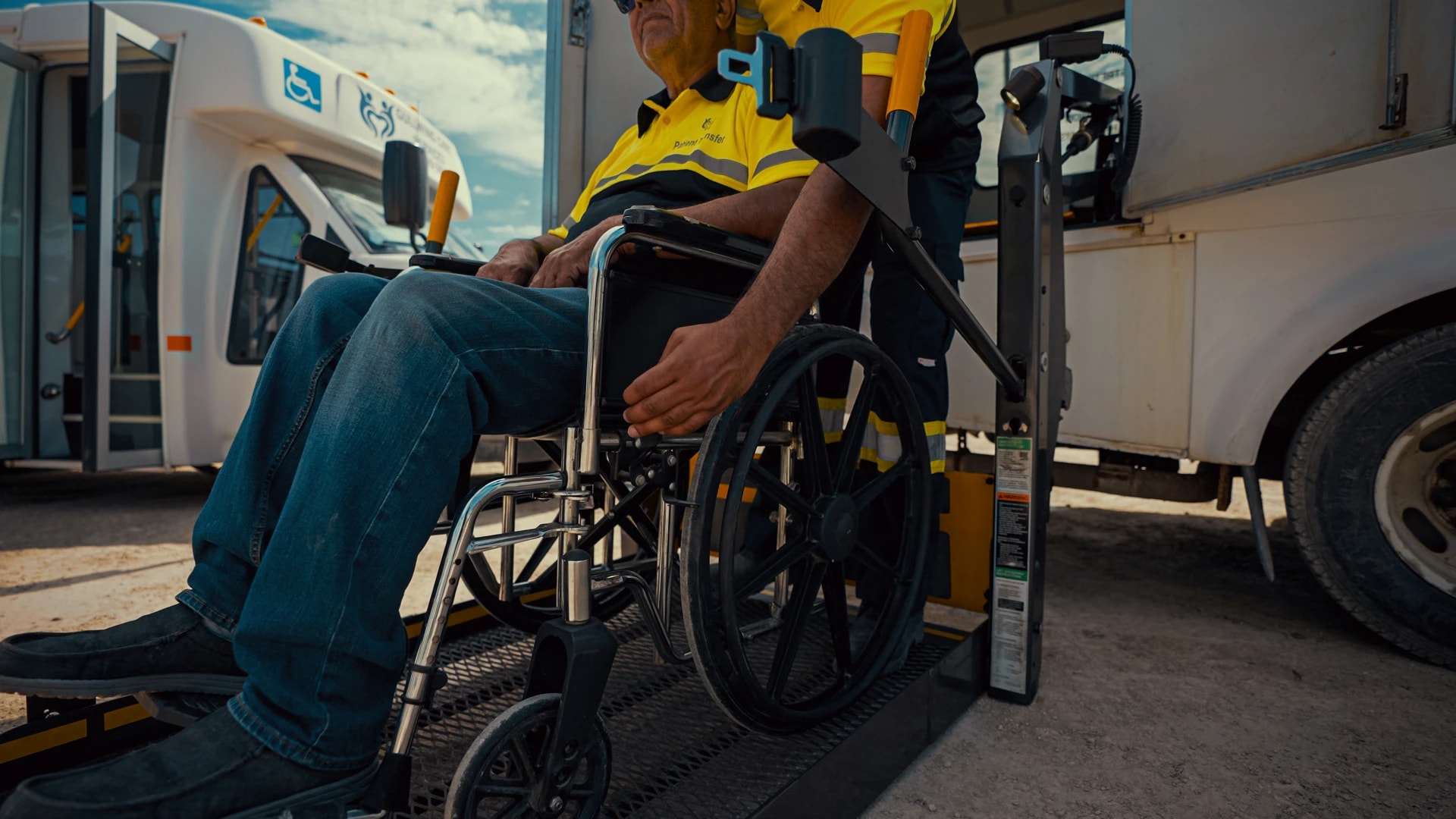 A seated passenger using a wheelchair beside an accessible vehicle