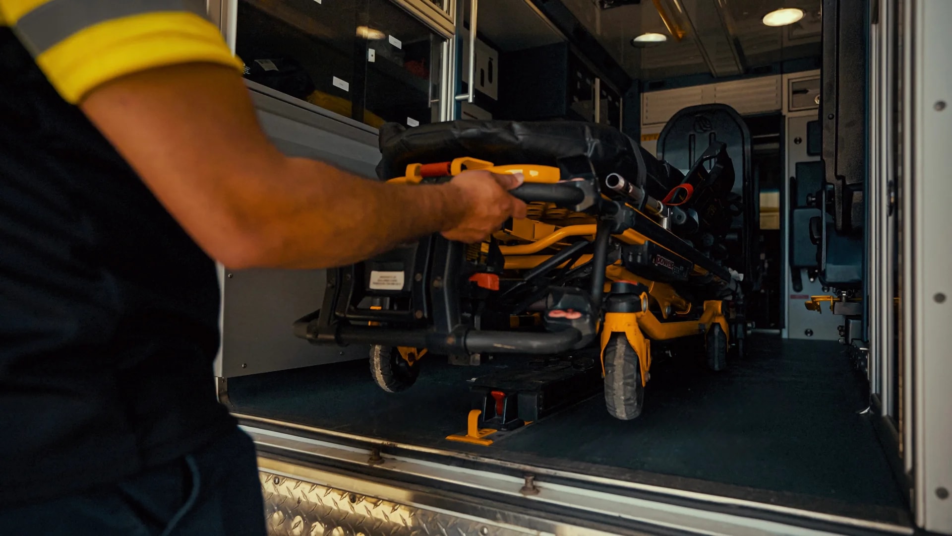 An attendant securing a stretcher inside a Gullwing Care vehicle