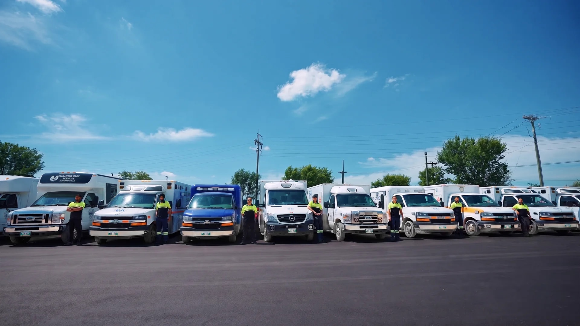 Gullwing Care team standing with the transport fleet