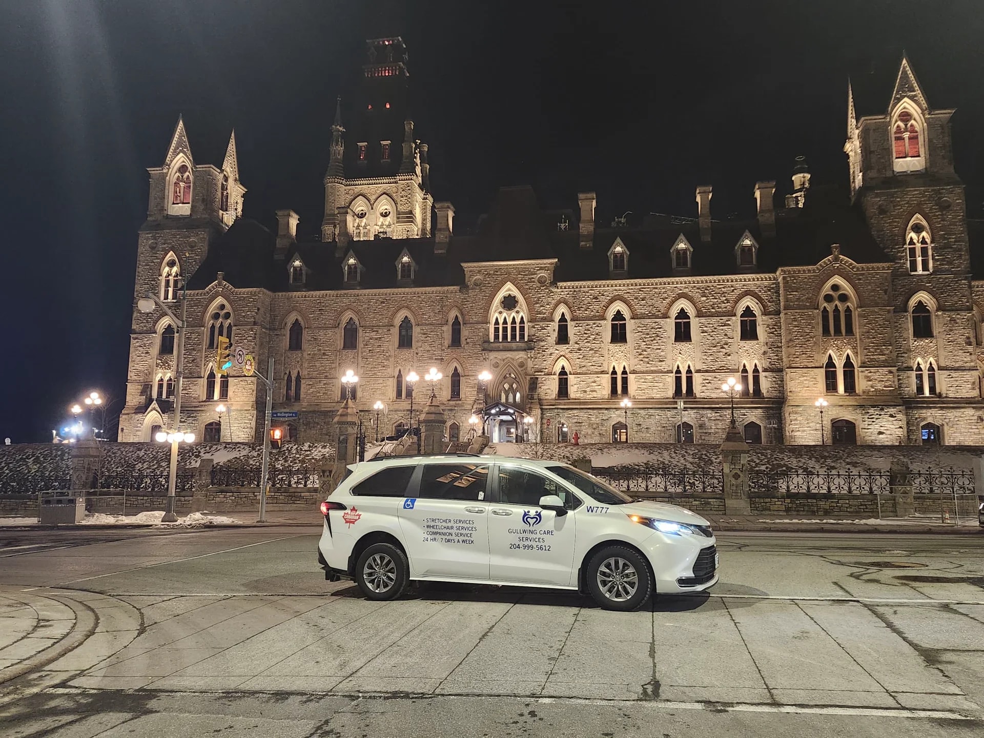 Gullwing Care minivan in front of an illuminated historic building