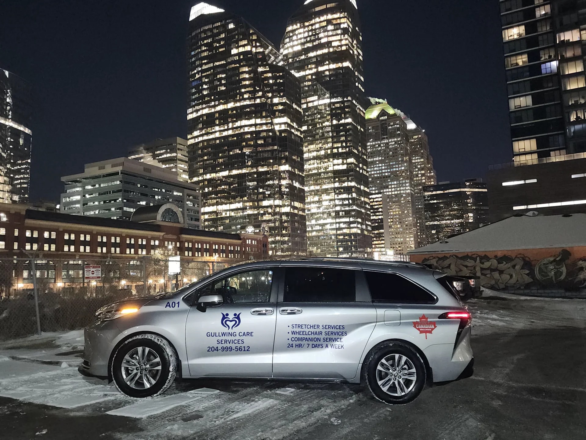 Gullwing Care minivan beside city buildings at night